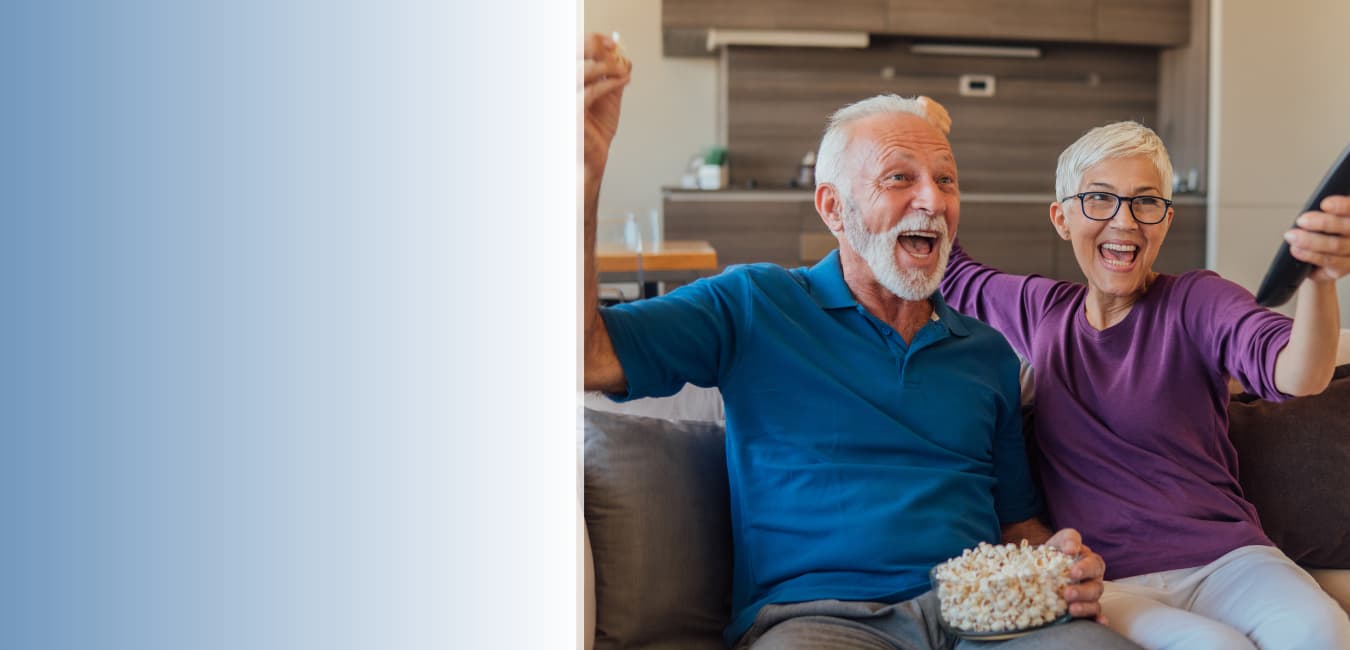 Senior couple enjoying television with popcorn